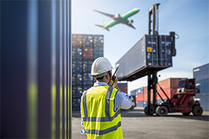 Container being moved in a port with plane overhead