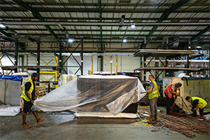 Polythene sheeting being placed over loaded PMC